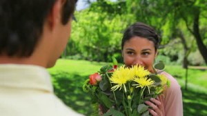 stock-footage-smiling-woman-receiving-a-bunch-of-flowers-in-a-parkland